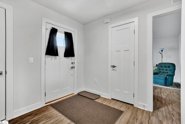 foyer entrance featuring wood finished floors and baseboards