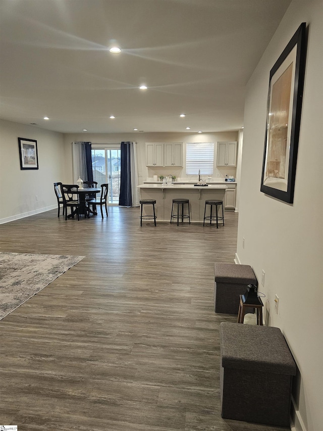 living room with baseboards, dark wood finished floors, and recessed lighting