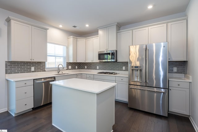 kitchen featuring dark wood-style floors, stainless steel appliances, light countertops, visible vents, and a sink