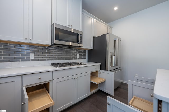 kitchen featuring dark wood-style flooring, recessed lighting, light countertops, backsplash, and appliances with stainless steel finishes