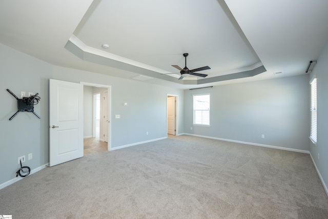 unfurnished bedroom featuring carpet, baseboards, visible vents, and a tray ceiling