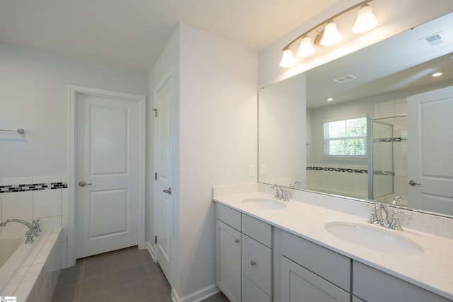 full bath with tile patterned floors, tiled shower, a sink, and a bath