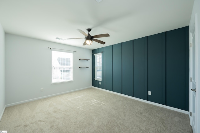 spare room featuring a ceiling fan, carpet, and visible vents