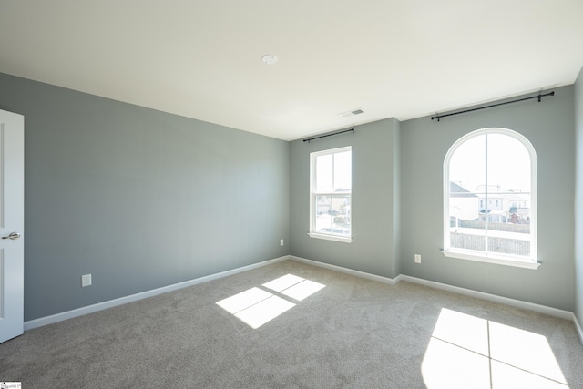 carpeted empty room with baseboards