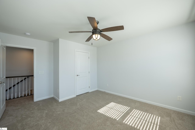 unfurnished bedroom featuring a ceiling fan, carpet, and baseboards