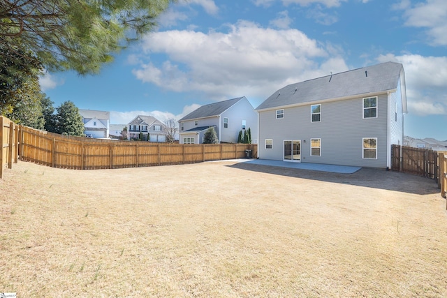 back of property featuring a fenced backyard, a residential view, and a patio