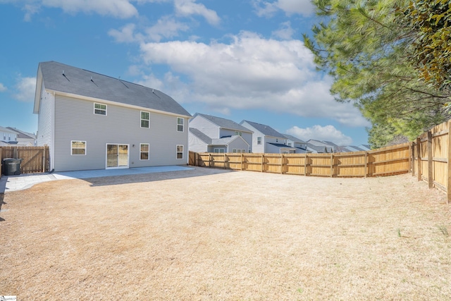 back of house with a fenced backyard and a patio