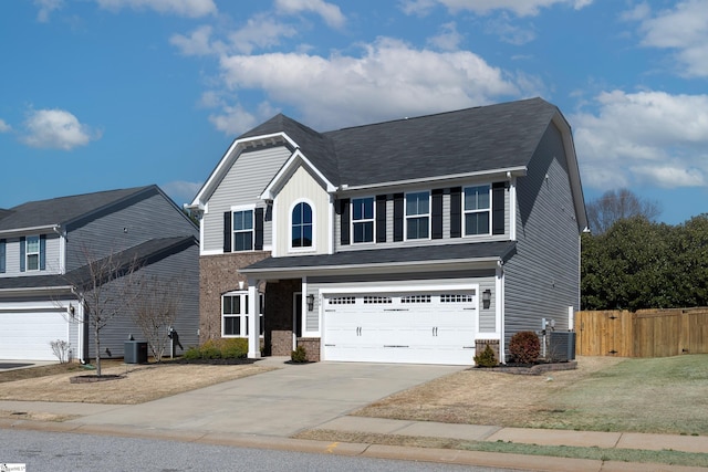 traditional-style house with driveway, an attached garage, fence, central air condition unit, and brick siding