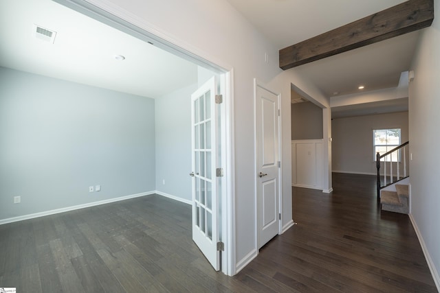 corridor with beam ceiling, dark wood-style flooring, visible vents, stairway, and baseboards