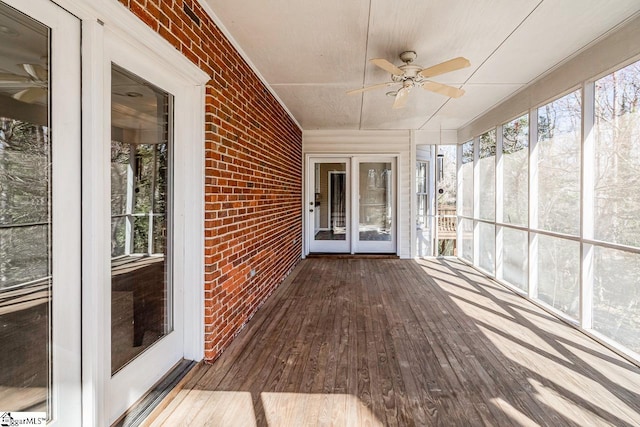 unfurnished sunroom with a ceiling fan