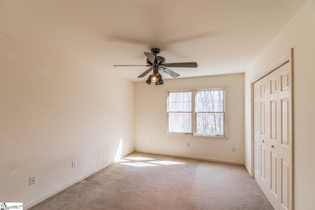 unfurnished bedroom featuring carpet, baseboards, ceiling fan, and a closet