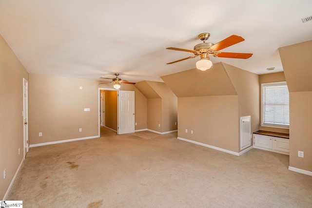 additional living space with light carpet, a ceiling fan, visible vents, and baseboards