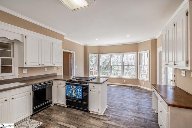 kitchen with dark wood-style flooring, a sink, a peninsula, and black appliances