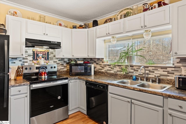 kitchen with dark countertops, a sink, a textured ceiling, under cabinet range hood, and black appliances