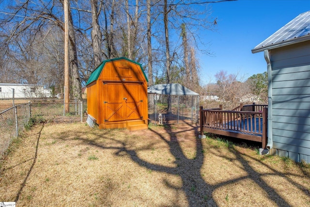 view of yard with a deck, a storage unit, an outdoor structure, and a fenced backyard