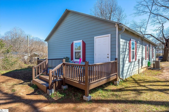 back of house with central AC, a yard, and a wooden deck