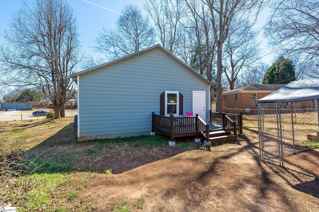 back of property featuring fence and a wooden deck