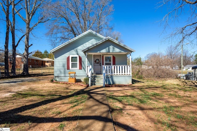 bungalow featuring covered porch and fence