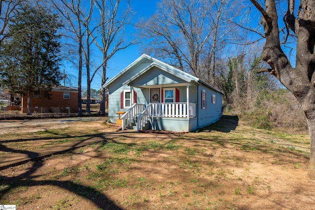 bungalow-style home with a front lawn and a porch