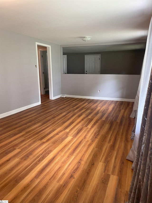 spare room featuring wood finished floors and baseboards