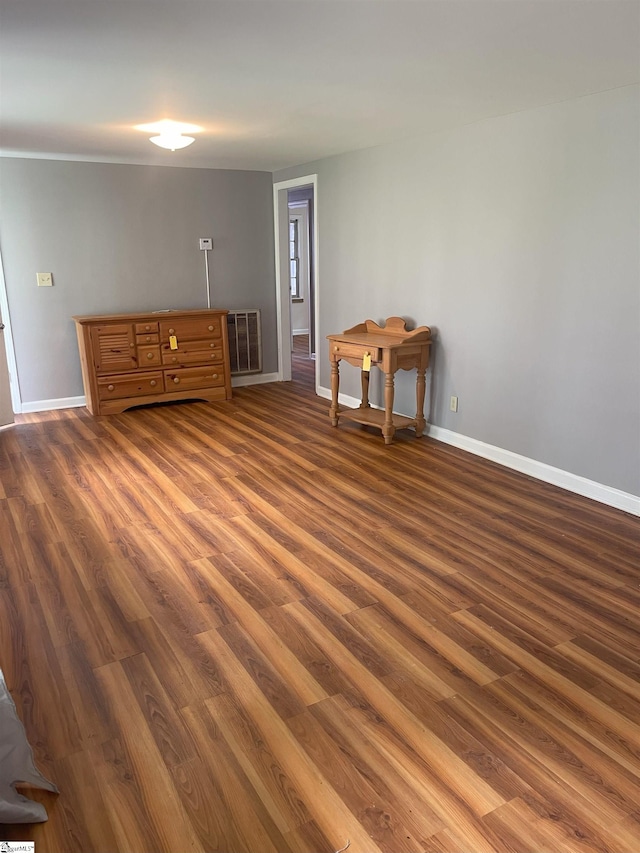 empty room featuring visible vents, baseboards, and wood finished floors