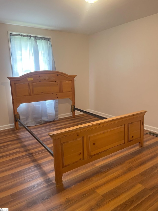 bedroom featuring dark wood-style flooring, visible vents, and baseboards