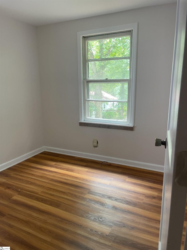 empty room featuring wood finished floors and baseboards