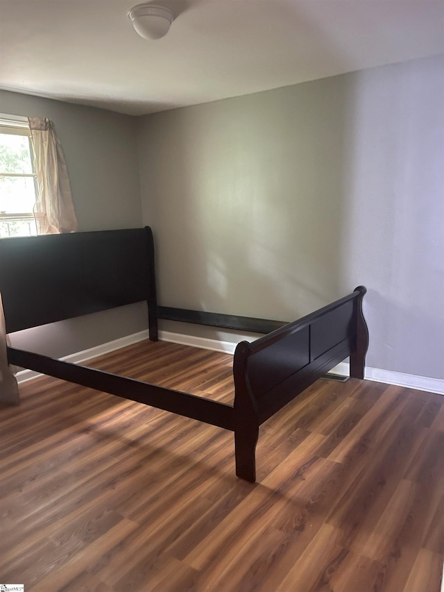 bedroom featuring baseboards and wood finished floors