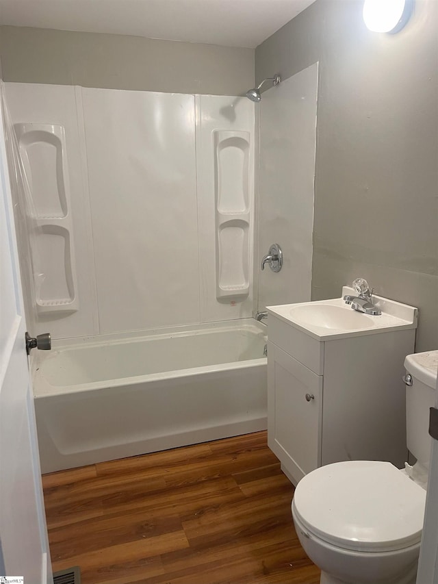 bathroom featuring  shower combination, vanity, toilet, and wood finished floors