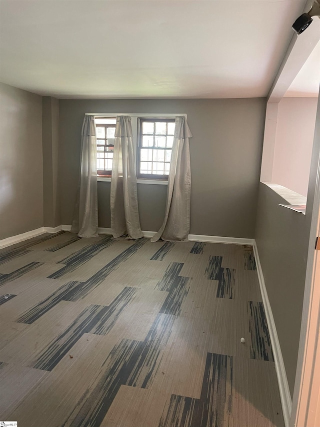 unfurnished room with baseboards