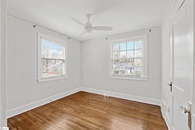 unfurnished room featuring baseboards, plenty of natural light, and hardwood / wood-style floors