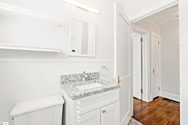 interior space featuring wainscoting, visible vents, vanity, and hardwood / wood-style flooring