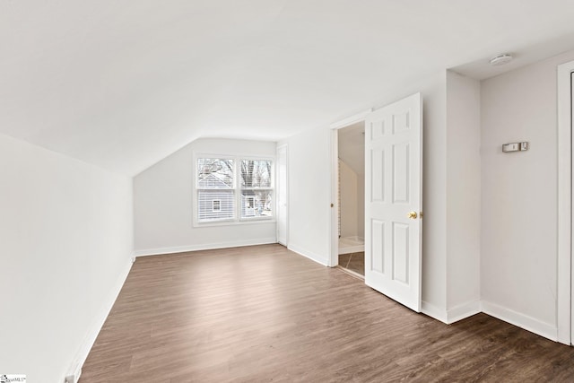 bonus room featuring lofted ceiling, baseboards, and dark wood-style flooring