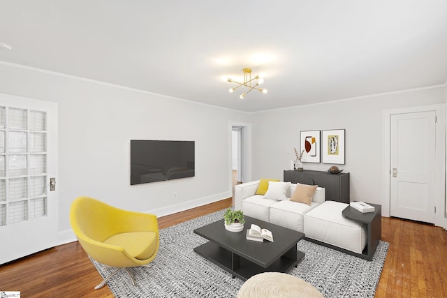 living area featuring baseboards, ornamental molding, wood finished floors, built in shelves, and a notable chandelier