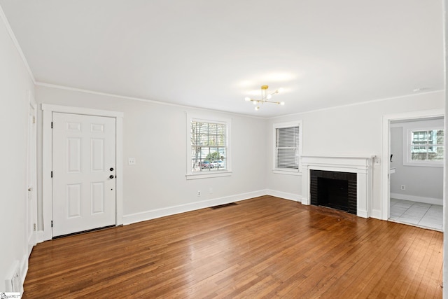 unfurnished living room with wood-type flooring, a healthy amount of sunlight, a fireplace, and baseboards