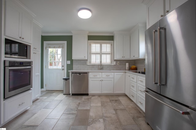 kitchen featuring backsplash, stainless steel appliances, a sink, and light countertops