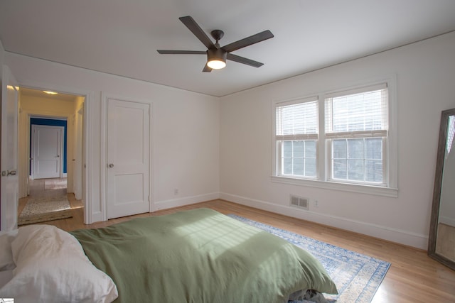 bedroom with visible vents, ceiling fan, baseboards, and wood finished floors