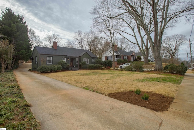 view of front of home featuring a front yard and a chimney