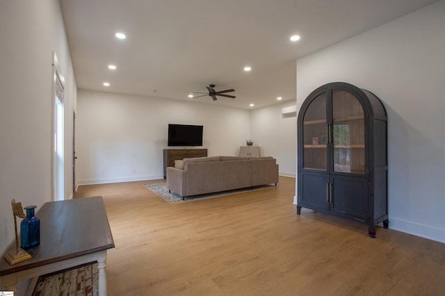 living area featuring light wood finished floors, baseboards, and recessed lighting