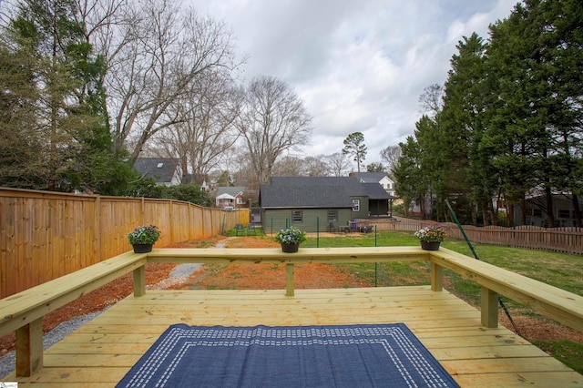 deck with an outbuilding, a fenced backyard, and a lawn