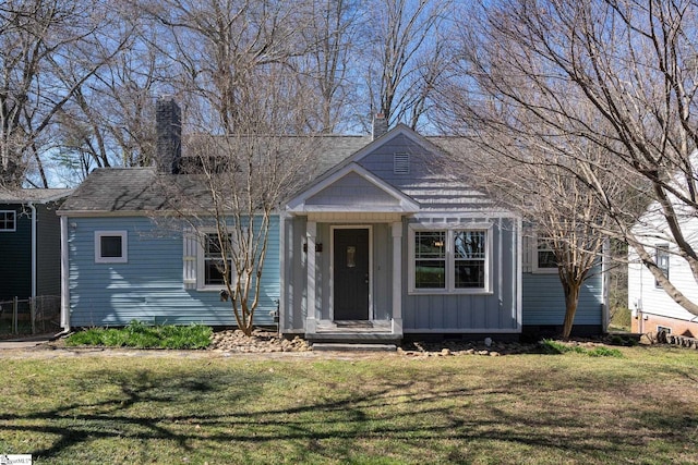 view of front of property featuring a front lawn, board and batten siding, and a chimney