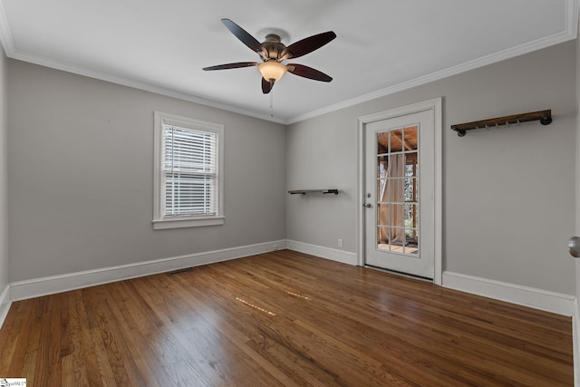 spare room with ceiling fan, crown molding, baseboards, and wood finished floors