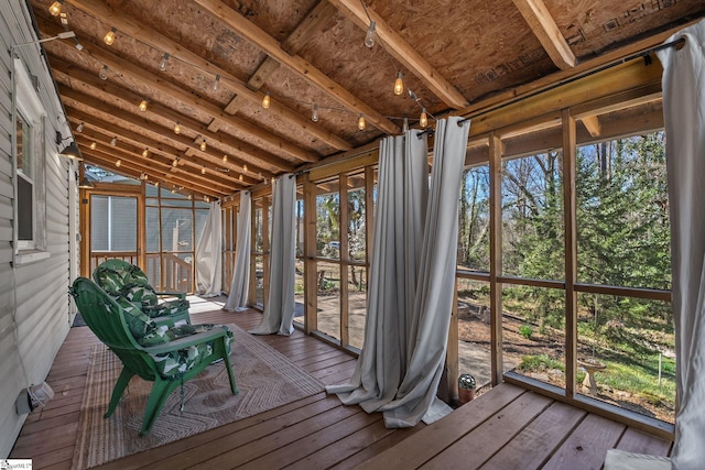 unfurnished sunroom featuring vaulted ceiling and a wealth of natural light