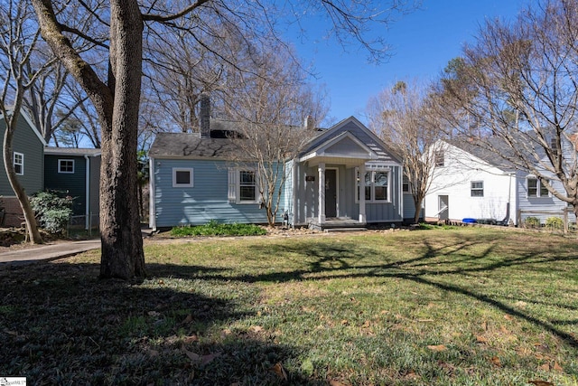 view of front of property with a chimney, a front lawn, and board and batten siding