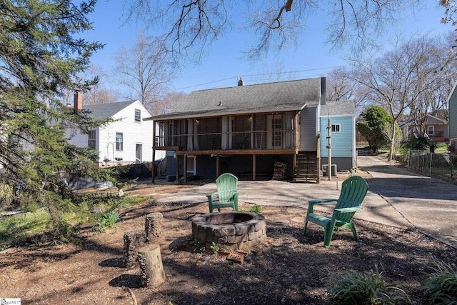 rear view of property with a fire pit, a sunroom, stairway, fence, and a patio area