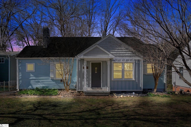 view of front of house with a yard, crawl space, and a chimney