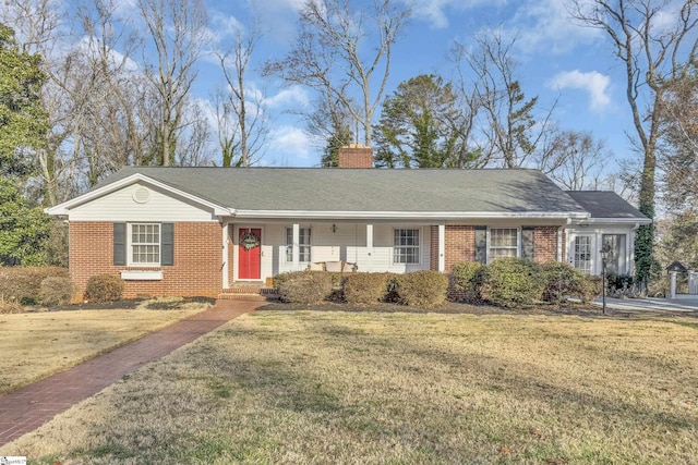 ranch-style house with brick siding, a chimney, a front yard, and a shingled roof