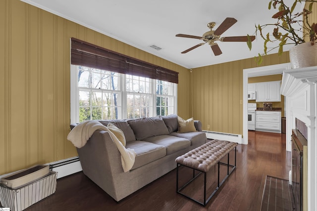 living area featuring dark wood-style floors, visible vents, baseboard heating, and a ceiling fan