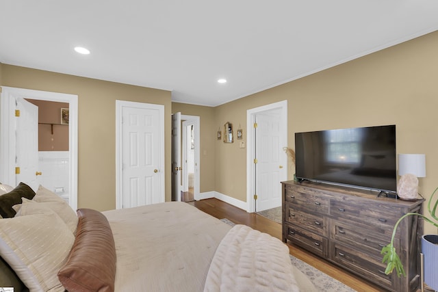 bedroom featuring connected bathroom, baseboards, dark wood-type flooring, and recessed lighting