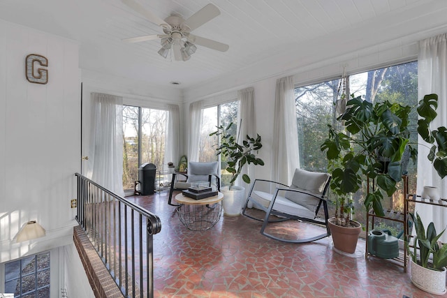 sunroom featuring a ceiling fan and wooden ceiling